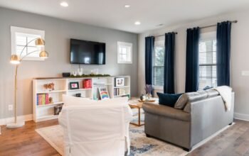 Bright small living room styled with a sofa, mirror and light colours