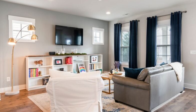 Bright small living room styled with a sofa, mirror and light colours
