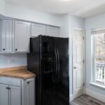 Modern UK kitchen with fridge freezer and large window