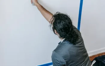 Person using a roller to paint a wall during a home renovation