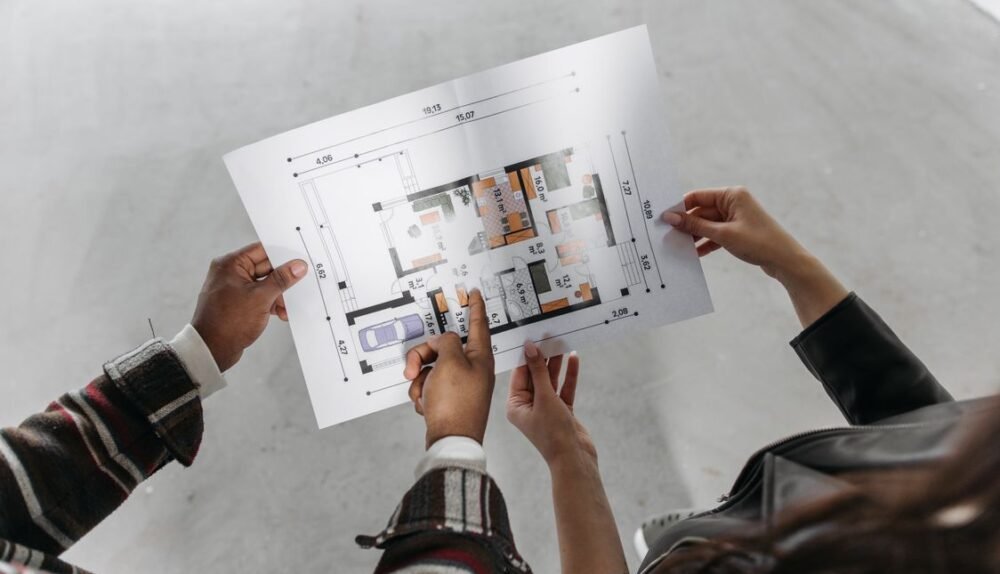 Couple reviewing house extension blueprint and planning permission documents