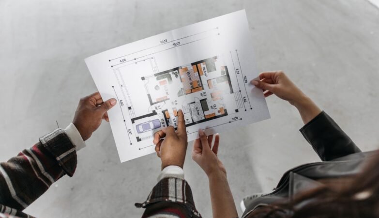 Couple reviewing house extension blueprint and planning permission documents