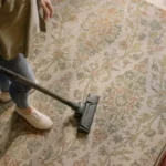 Woman vacuuming a patterned carpet at home