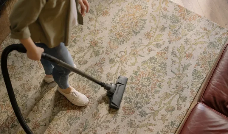 Woman vacuuming a patterned carpet at home
